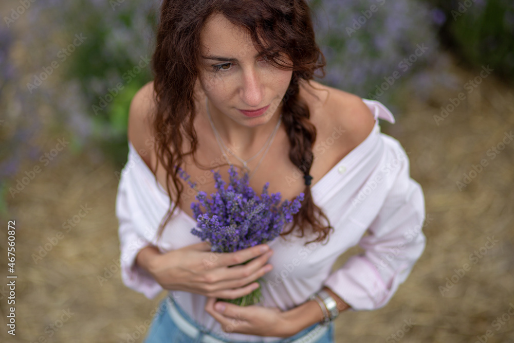 Closeup happy beautiful girl enjoying lavender field with bouquet of flowers Closeup happy beautiful girl enjoying lavender field with bouquet of flowers