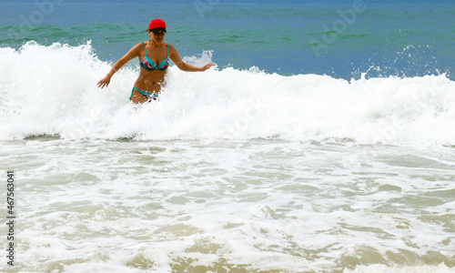 A girl swims in the sea. Beach holidays. Big waves. Tropical climate. A happy woman. © kseny90