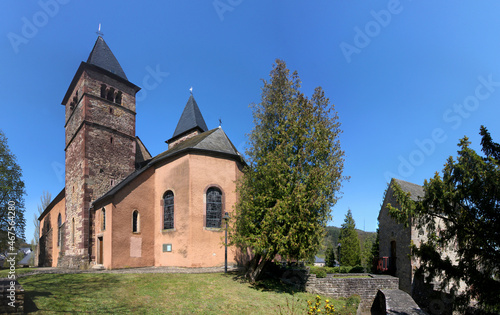Medieval church of St Peter and Paul with its romanesque bell towers in a park in the old town of Echternach, Luxemburg photo