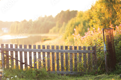 Fence in the rays of sunshine. Rural landscape. 