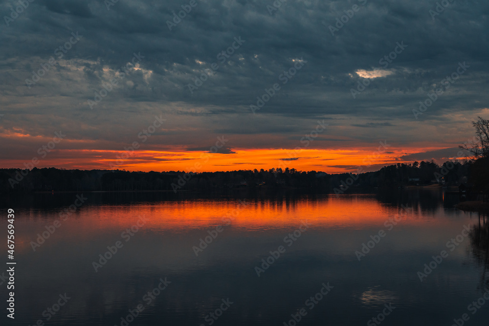 Beautiful sunset by a lake, with a spectacular sky and red and orange clouds