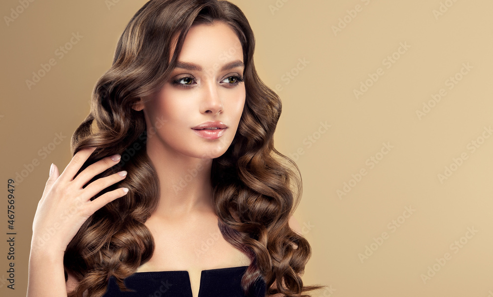 Naklejka premium Beauty girl with long and shiny wavy hair . Beautiful woman model with curly hairstyle . Fashion, cosmetics and makeup