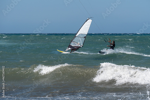 Kitesurfing and Windsurfing During a Windy Day with a Very Rough Sea