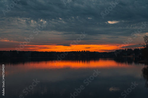 Beautiful sunset by a lake, with a spectacular sky and red and orange clouds