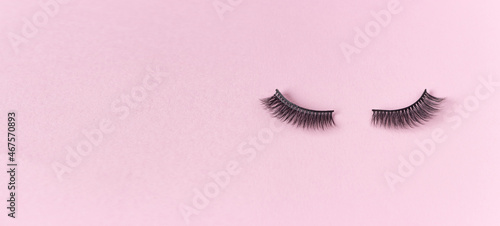 Artificial eyelashes on a pink background, free space for text. The concept of eyelash extensions, makeup.