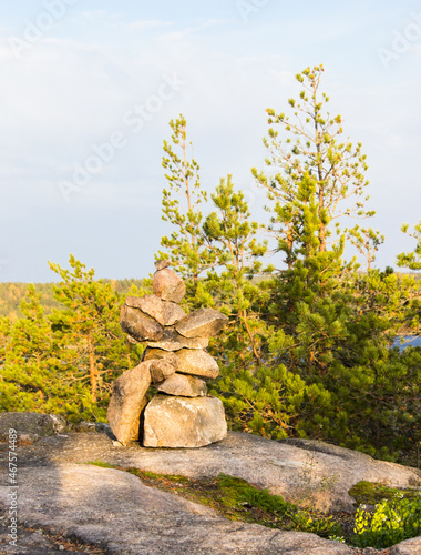Pyramid made by stones. Stone tower and forest in the background. Rocks on the pine forest. Stone pile was made by tourist. Beautiful landscape. Concept of balance, harmony and vacation.