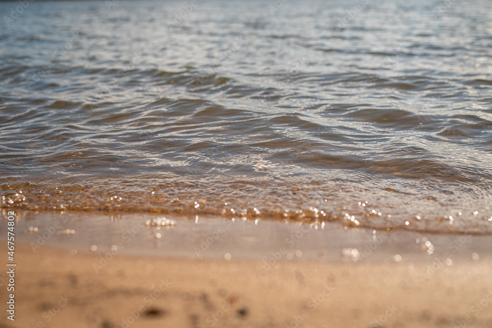 A wave floats on the shore of the lake forming bubbles A wave floats on the shore of the lake forming bubbles