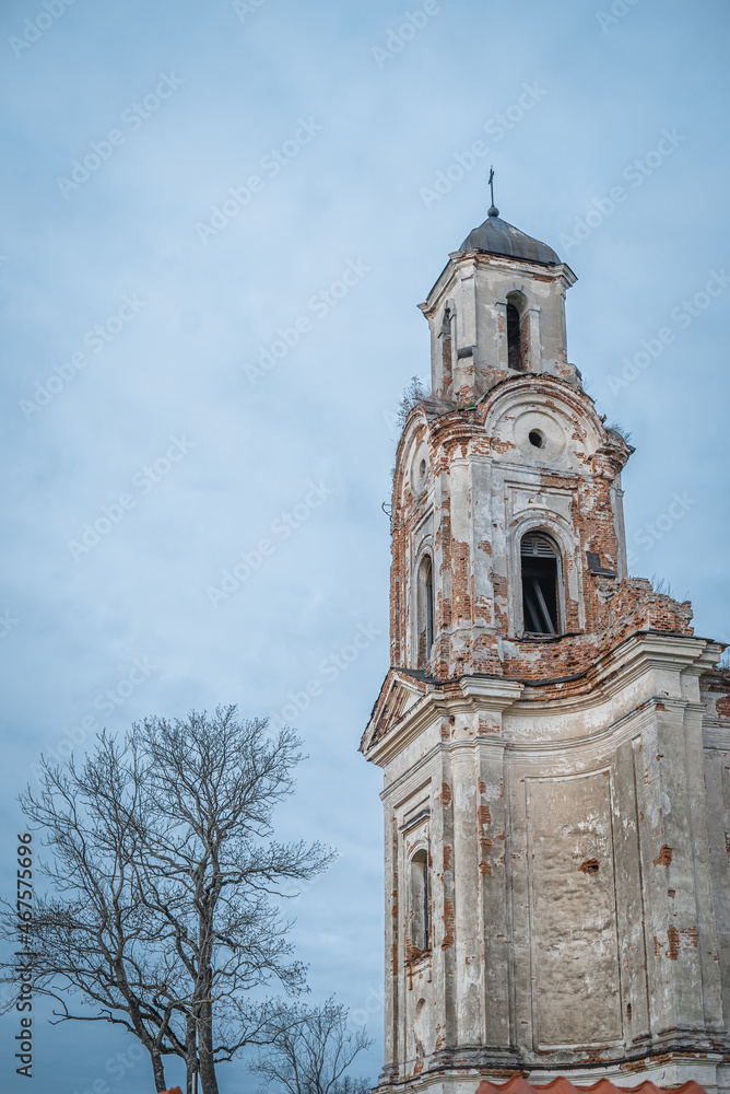 Fototapeta premium The ruined tower of the old church against the background of the evening blue sky