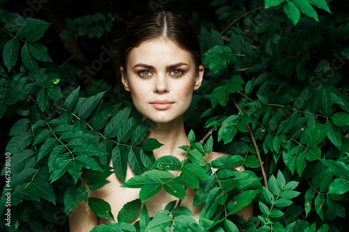 portrait of a woman skin care bare shoulders green leaves nature close-up