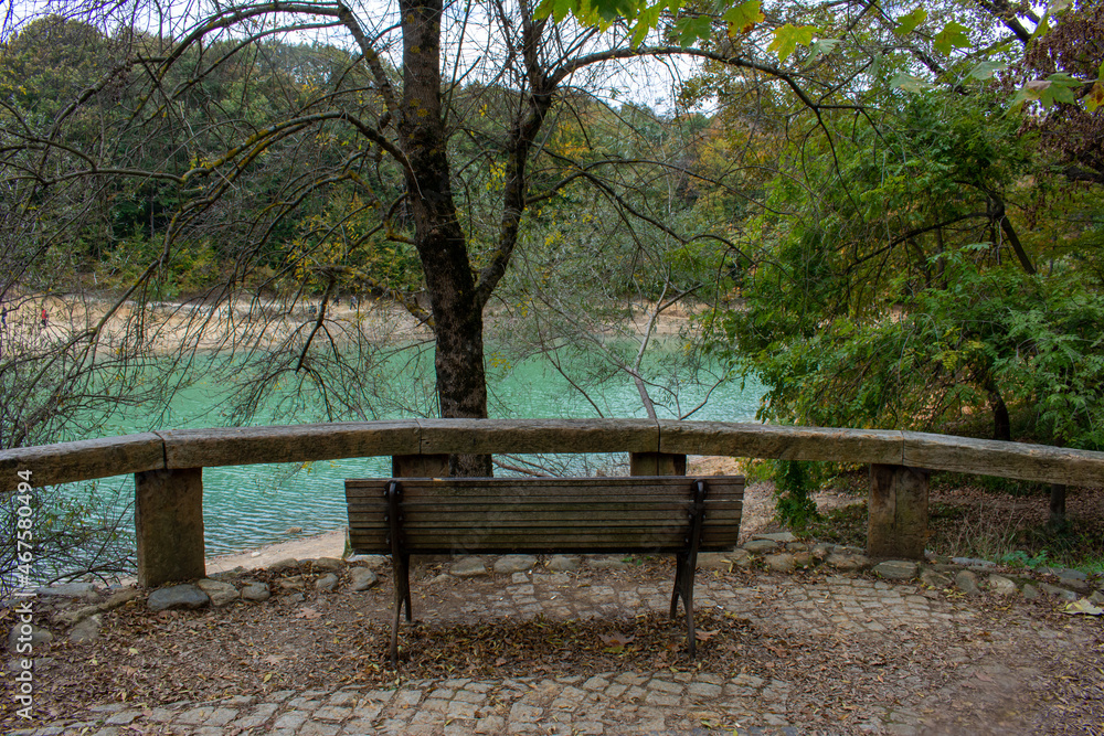 An empty wooden bench by the lake. Calmness, rest, sitting in nature. An empty wooden bench by the lake. Calmness, rest, sitting in nature.