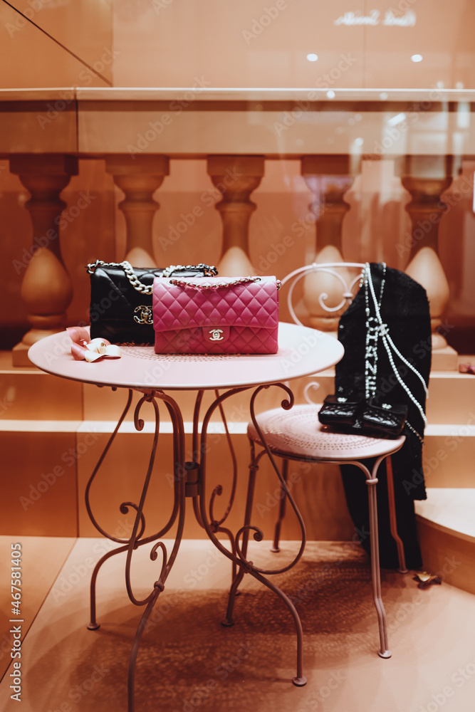 Pink and black Chanel handbags in the window of a luxury store