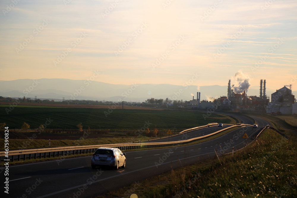 Samochody na drodze szybkiego ruchu, krajobraz wiejski przed zachodem słońca. - obrazy, fototapety, plakaty 