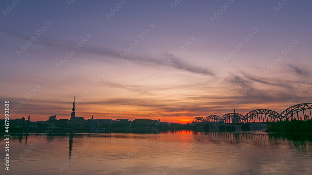 Sunrise over old Riga reflected in the mirror of the Daugava