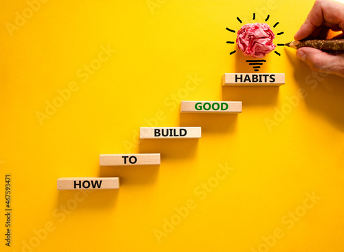 Build good habits symbol. Wooden blocks on beautiful yellowbackground, copy space. Words 'How to build good habits'. Businessman hand, light bulb. Build good habits concept. Copy space. photo