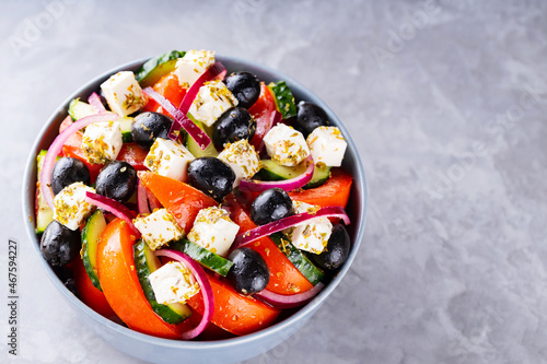 Greek salad with feta and olives on a gray background. Healthy mediterranean salad. Copy space. Top view