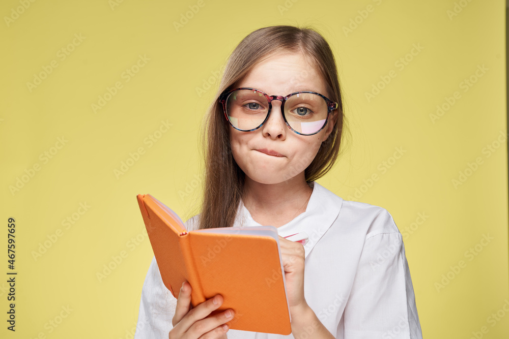 schoolgirl with textbook in hands learning childhood yellow background schoolgirl with textbook in hands learning childhood yellow background