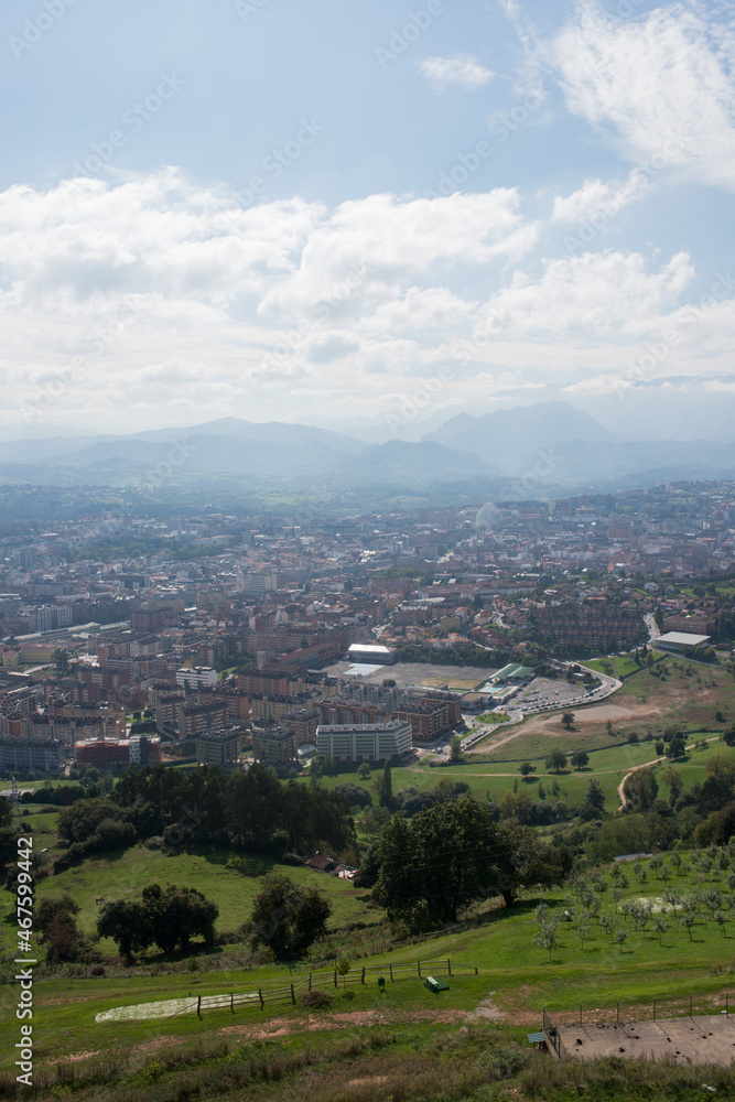 Beautiful aerial view of Oviedo. Green fields and mountains around the city. Sunny day, no people. Asturias
