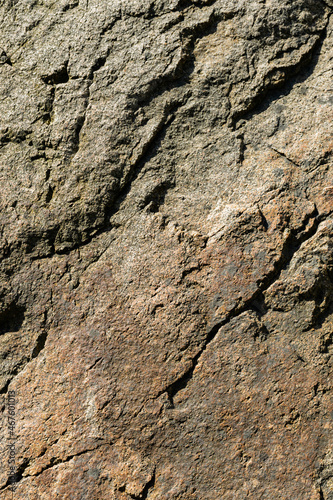 Texture of granite rock. Cracked stone surface from weathering. Close up of granite surface. Earth color concept