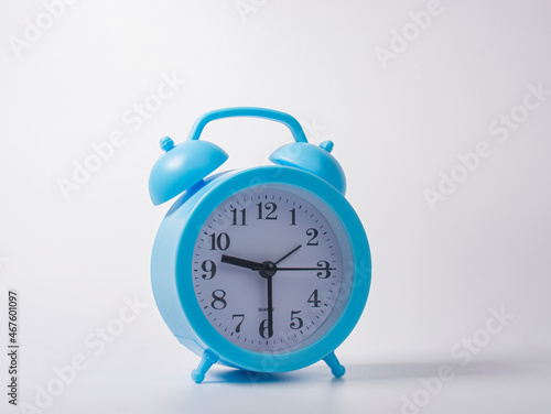 blue plastic alarm clock with large Arabic numerals on a white background.