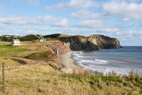 Fall landscape with beach and pretty traditional houses perched on cliff in the background, Havre-aux Maisons, Magdalen Islands, Quebec, Canada photo