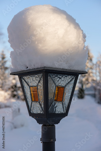 Vintage outdoor lantern in the garden in winter under the snow.