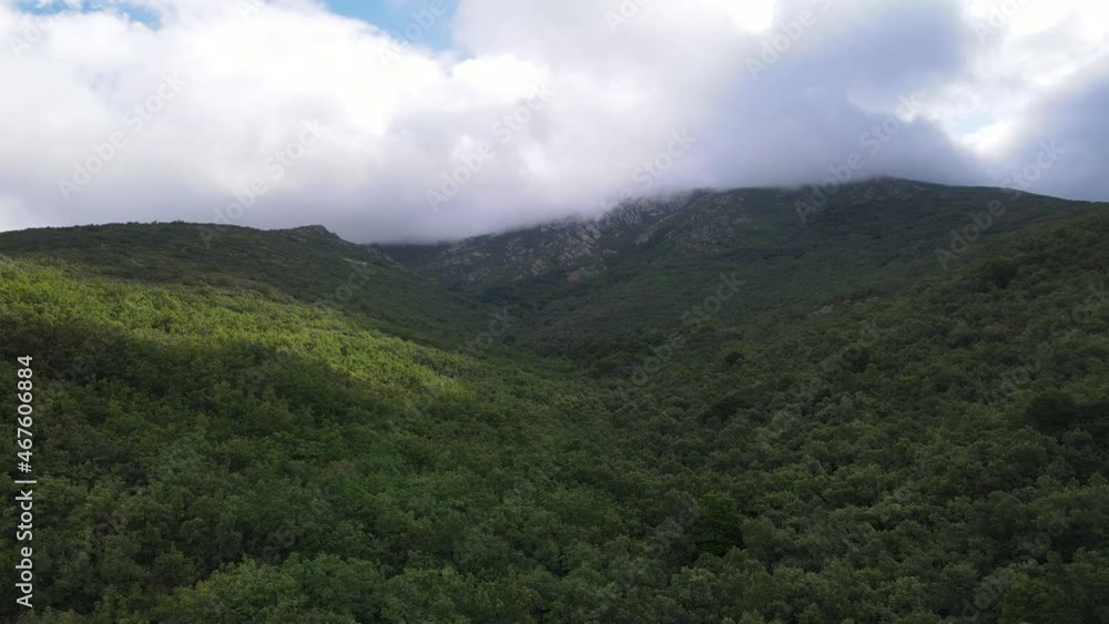 Big green mountain with clouds on top and sun rising from behind the mountain. Somosierra Madrid. Big green mountain with clouds on top and sun rising from behind the mountain. Somosierra Madrid.