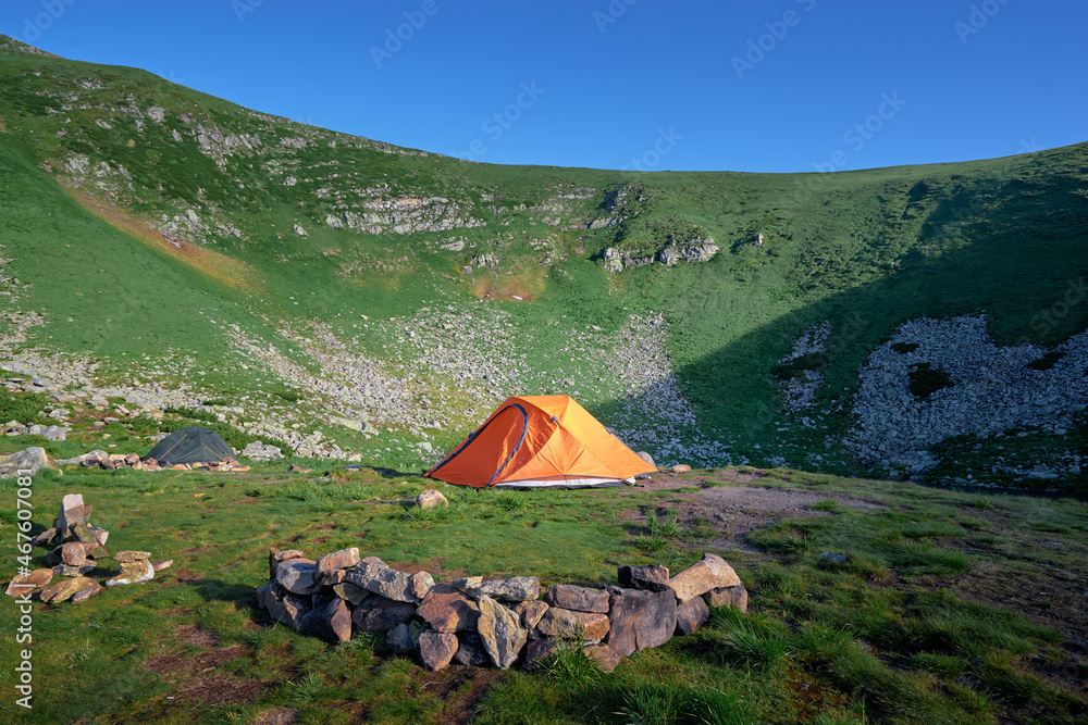 Tourism and traveling concept. Beautiful summer landscape with mountains and tourist tent.