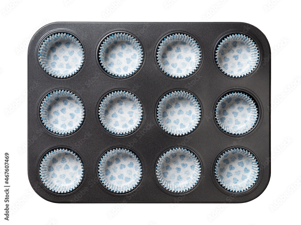 Muffin cake pan with paper baking cups isolated on a white background.  Empty 12-cup muffin non-stick baking tray with paper corrugated molds.  Baking dish for cupcake and pastries. Kitchen utensils. foto de