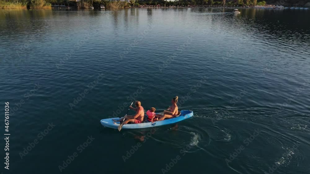 People are swimming in a blue kayak. Close-up from drone People are swimming in a blue kayak. Close-up from drone
