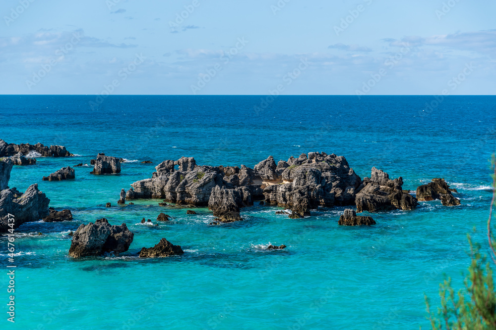 Tobacco Bay's Coastal Charm: St. George's, Bermuda; where sturdy rocks frame azure waters, a picturesque blend of nature's beauty.