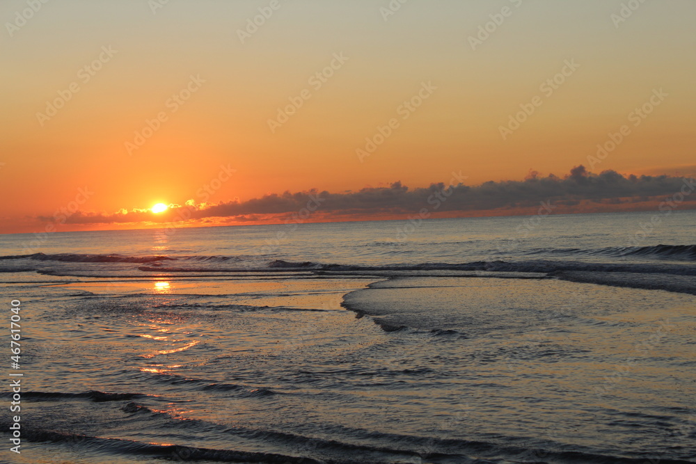 Naklejka premium Sunrise Over the Beach
