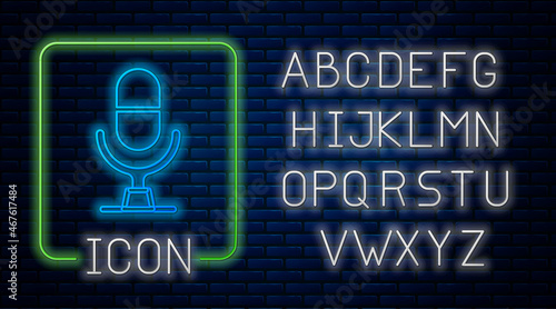 Glowing neon Microphone voice device icon isolated on brick wall background. Microphone interpreter and alphabet letters. Neon light alphabet. Vector