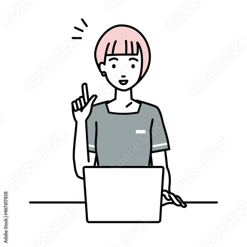 デスクで座ってPCを開いて何かひらめいたエステ店員の女性