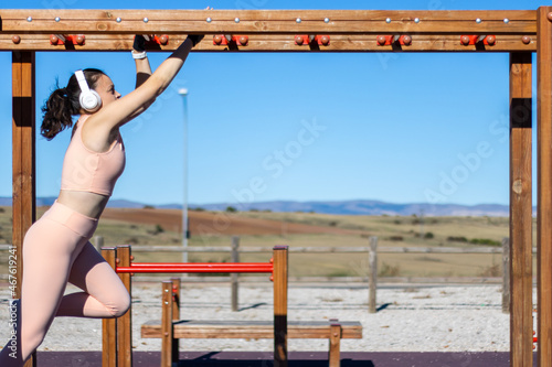 Fotografija Exercise fitness woman athlete exercising on monkey bars