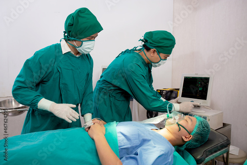 Team doctor and assistant preparation surgery and oxygen mask with patient emergency in the operation room at hospital  surgeon healing and surgery with looking monitor  problem of breathing.