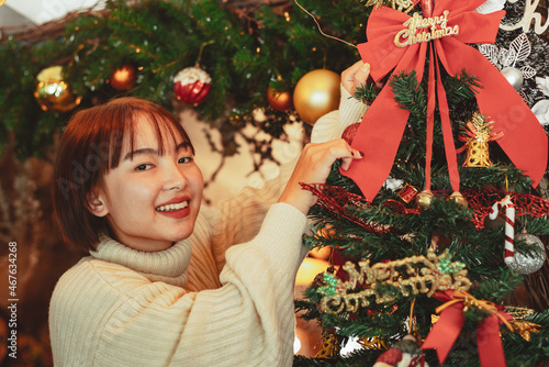 winter holidays concept, Happy woman Decorating Christmas tree for New Year celebration.