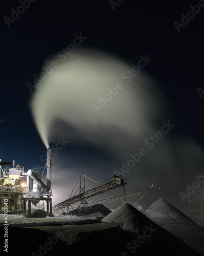 Panorama of working stone crushing machine at night at the mining factory  long exposure. Quarry mining  equipment.