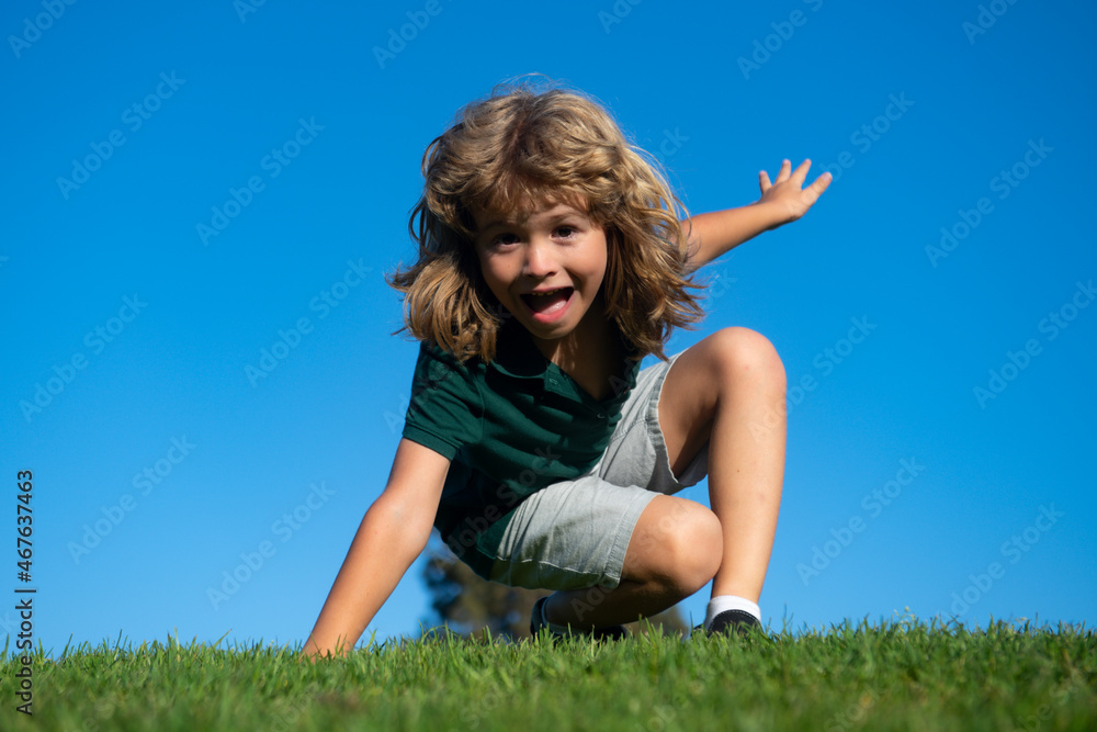 Happy little blond child laying on the grass in the park. Smmer day during school holidays. Amazed kid boy dreaming and smiling outdoor. Happy little blond child laying on the grass in the park. Smmer day during school holidays. Amazed kid boy dreaming and smiling outdoor.