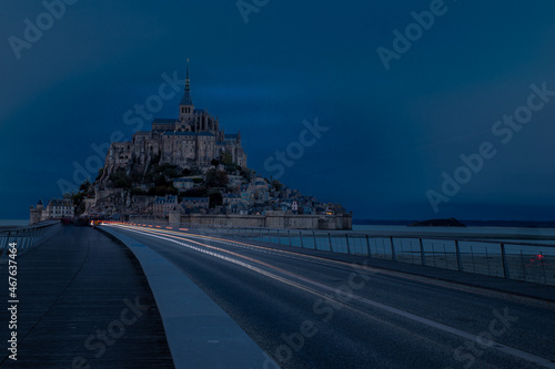 Le mont Saint Michel à l'heure bleue avec des phares de voitures en pose longue