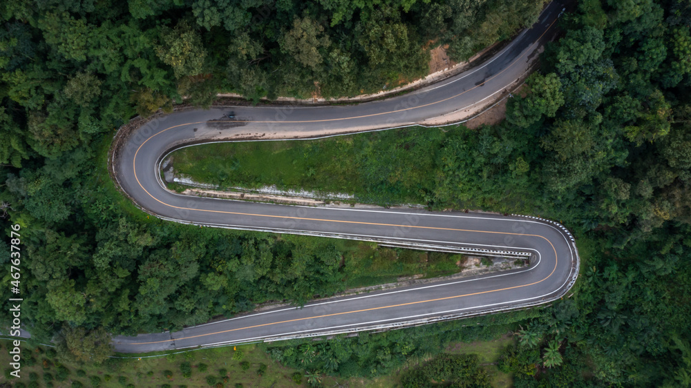 Aerial view asphalt road in mountain pass with green forest, Countryside road passing through the green forrest and mountain.