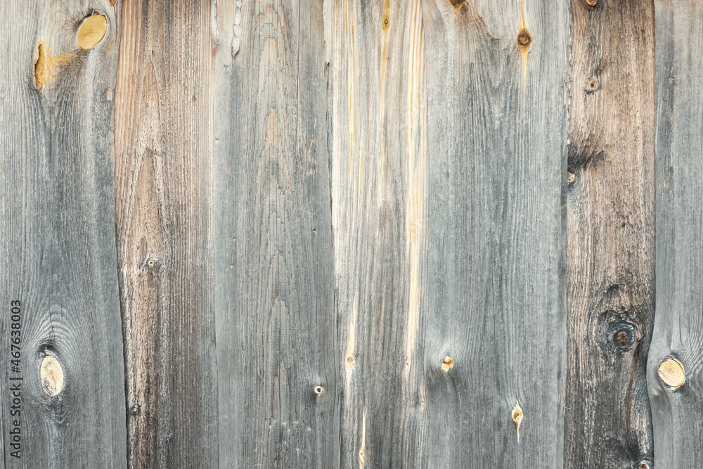 Fragment of the wall of an old wooden barn. The surface of the boards is gray from the influence of nature and time. Background. Texture. Fragment of the wall of an old wooden barn. The surface of the boards is gray from the influence of nature and time. Background. Texture.