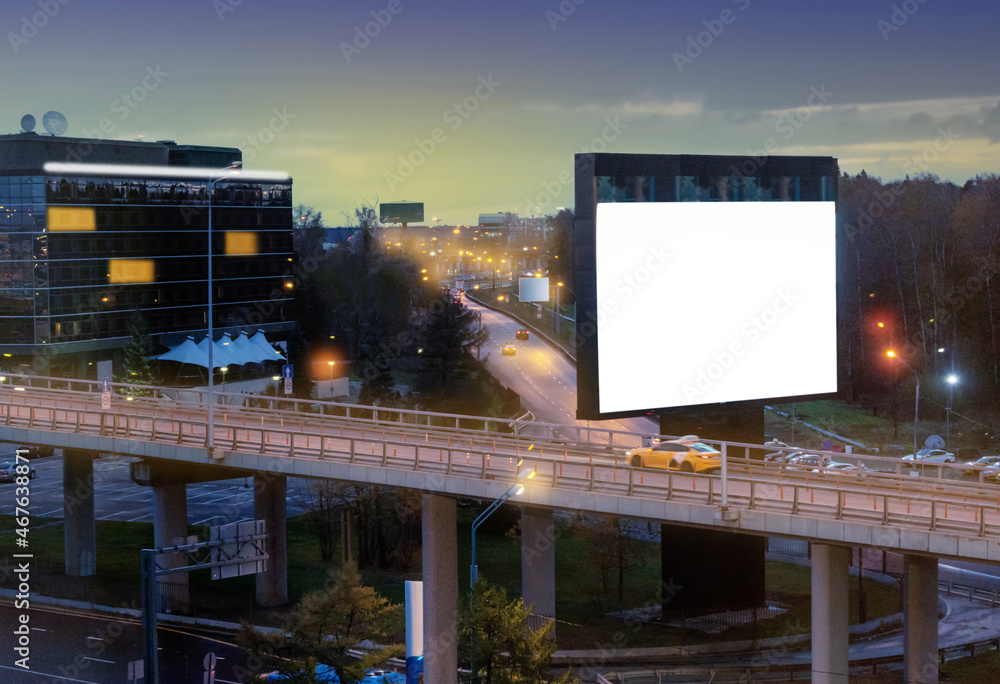 Blank billboard on night street of city.