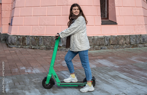 Happy young woman on electric scooter in the city.