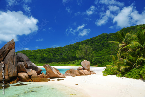 Anse Cocos beach with big granite stones in La Digue Island, Indian Ocean, Seychelles. Tropical landscape with sunny sky. Exotic travel destination.