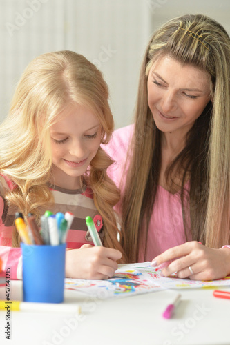 Mother and daughter drawing with her little girl