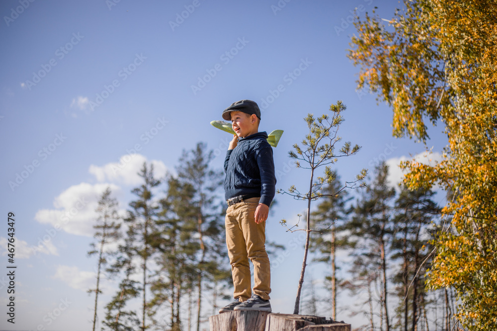Young boy play with toy airplaine in hands. Happy Kid is playing in park outdoors Young boy play with toy airplaine in hands. Happy Kid is playing in park outdoors