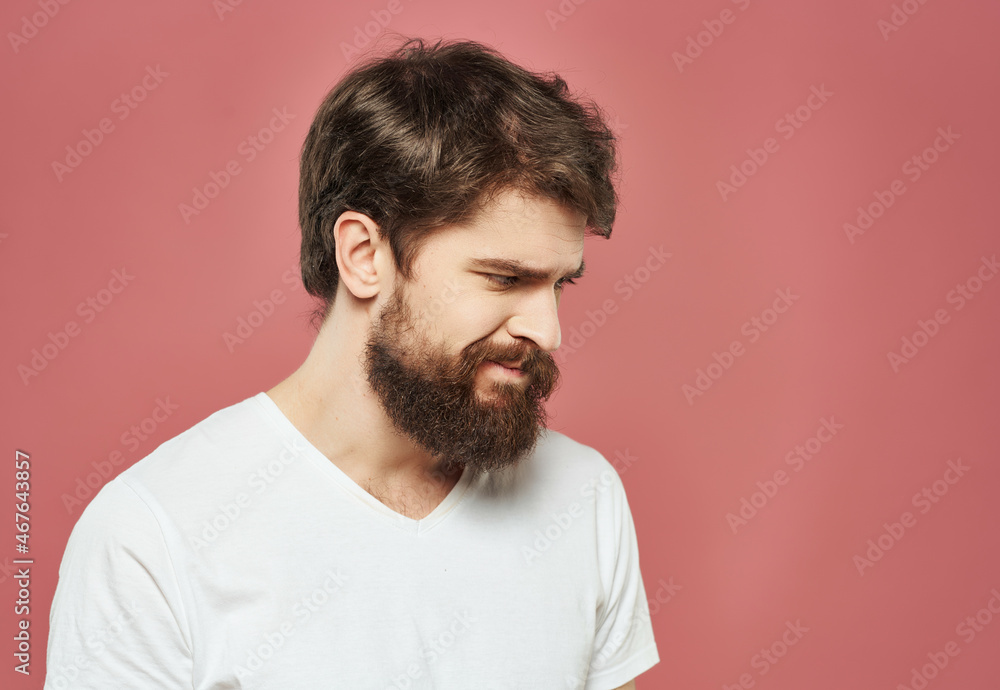 bearded man in a white t-shirt expressive look discontent pink background bearded man in a white t-shirt expressive look discontent pink background