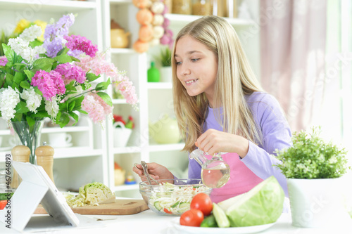 Portrait of cute girl preparing fresh salad