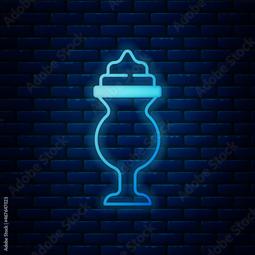 Glowing neon Milkshake icon isolated on brick wall background. Plastic cup with lid and straw. Vector