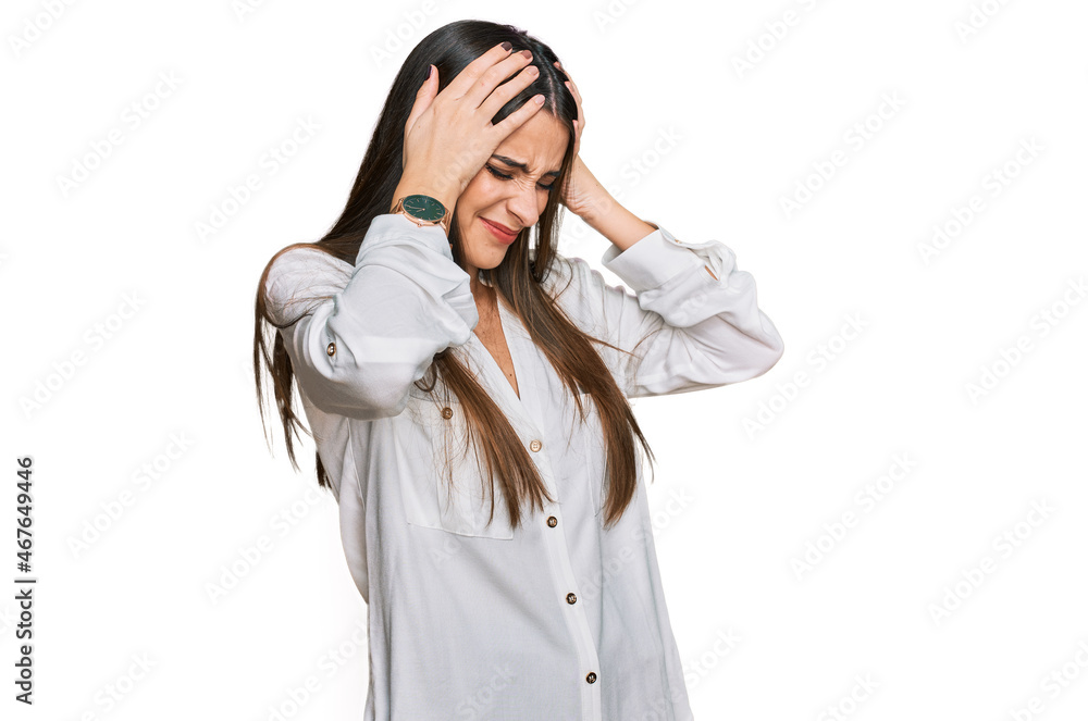 Young beautiful woman wearing casual white shirt suffering from headache desperate and stressed because pain and migraine. hands on head. Young beautiful woman wearing casual white shirt suffering from headache desperate and stressed because pain and migraine. hands on head.